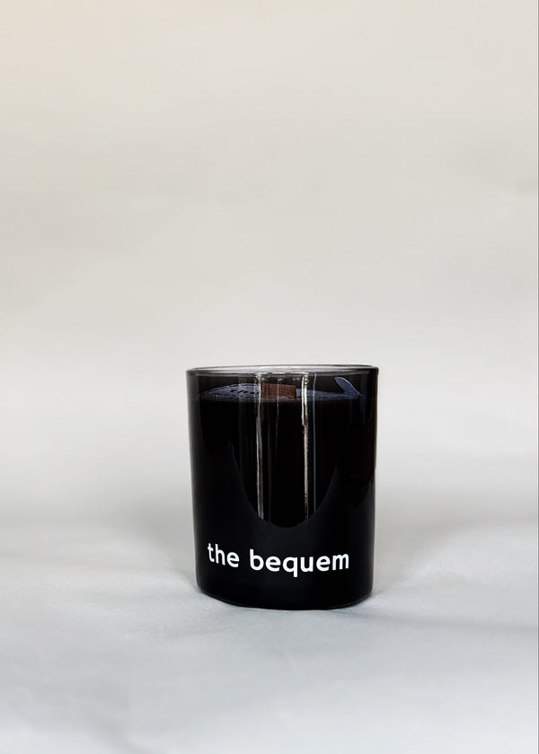 Black soy wax candle with 'the bequem' branding on a white background