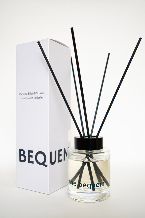 Reed diffuser by The Bequem in clear glass bottle with black reeds and packaging box, hand-poured in Berlin.